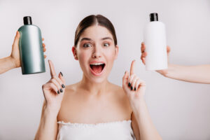 Closeup portrait of joyful girl posing without makeup on white background. Woman chose which shampoo is best to use.